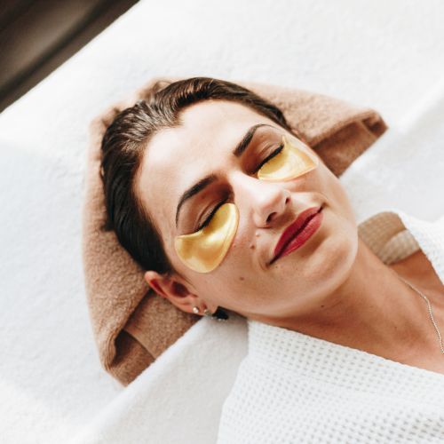 A person wearing a straw hat and yellow sunglasses, lying or reclining in a white shirt, with a relaxed, sunny vibe.