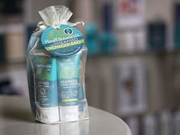 A small gift set of blue Seaweedhand and Body Wash products wrapped in sheer fabric with a circular blue label on top.